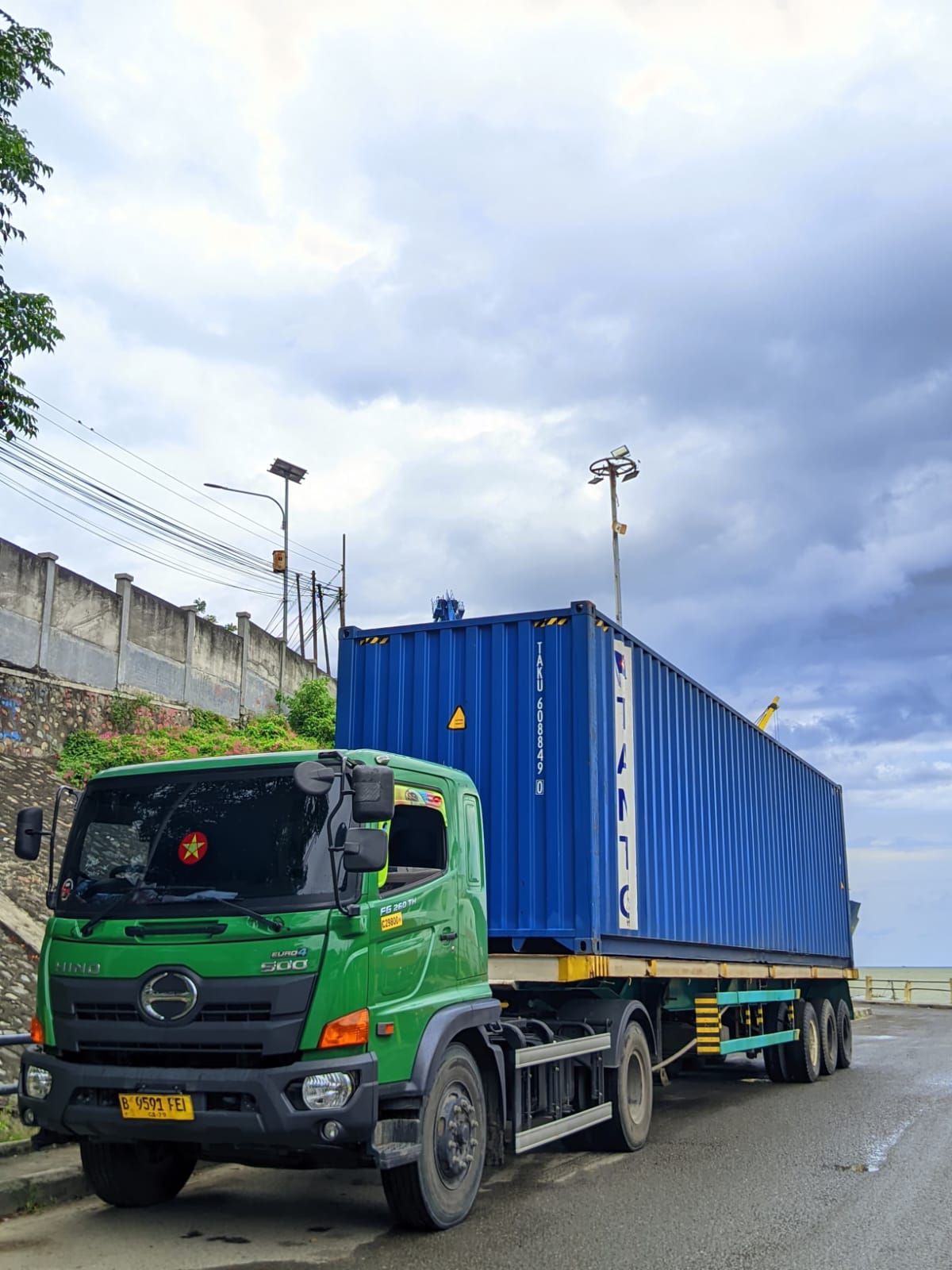 Truk Hino hijau membawa container biru dalam kegiatan JPT Anugerah Bahari
